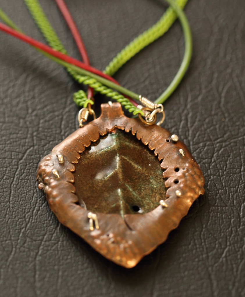 Back of makomako medallion with inverted makomako pierced